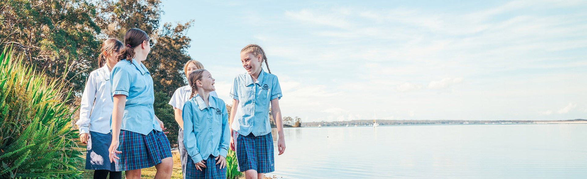 Brightwaters students in light blue uniform walking along Lake Macquarie waterfront