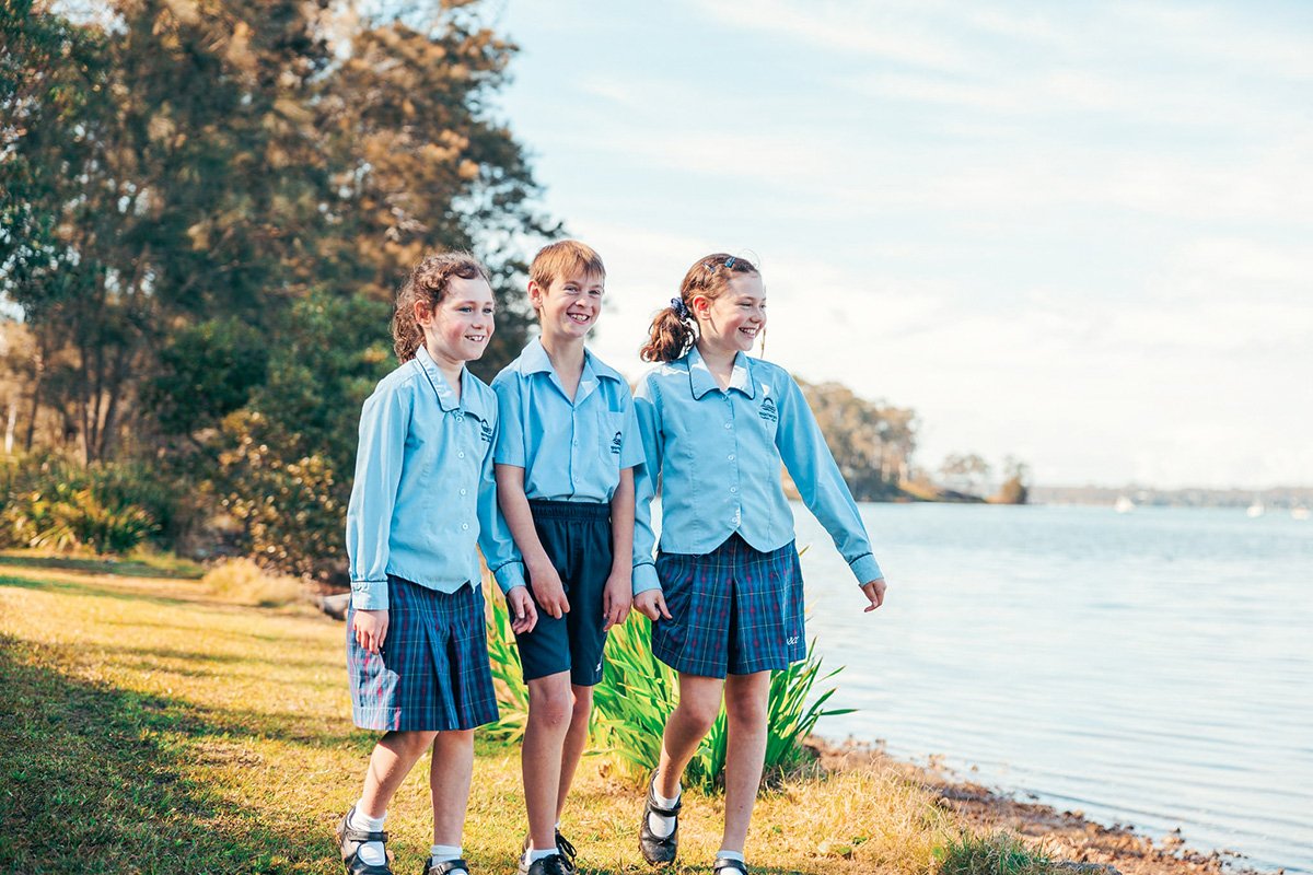 Three happy Brightwaters students walking together along shoreline of Lake Macquarie
