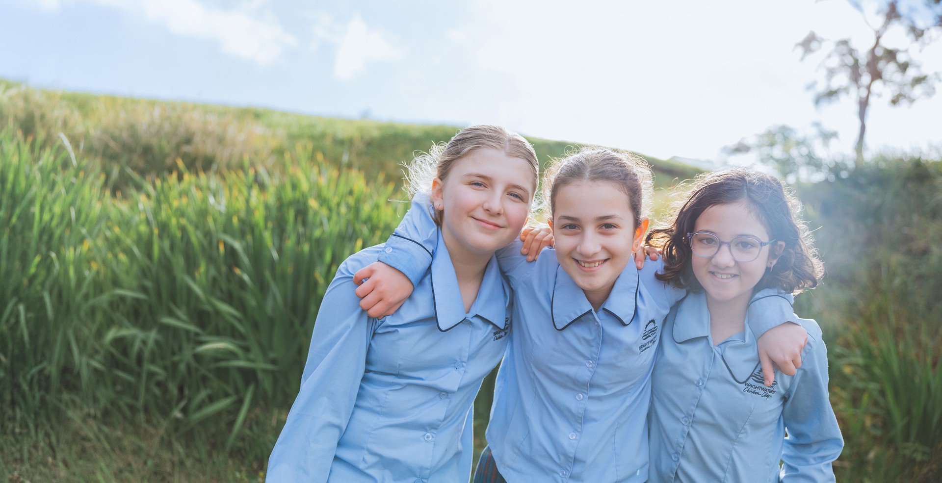 Three happy Brightwaters Christian College students who are hugging