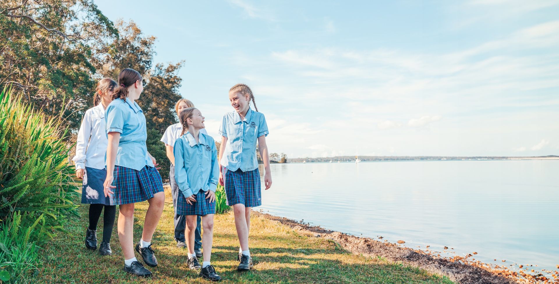 Laughing christian school students in uniform on Lake Maquarie waterfront